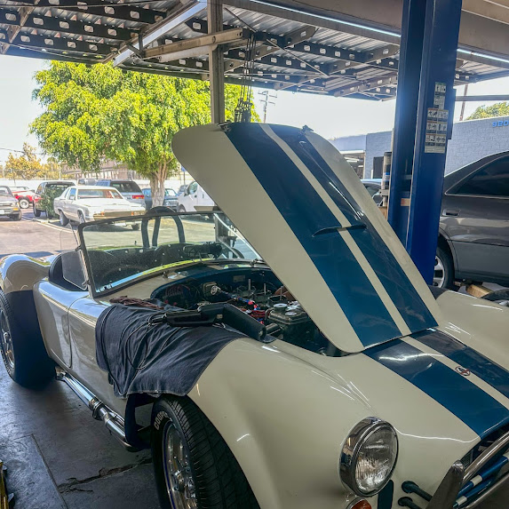 Shelby Cobra with hood up at Alamilla's Carburetors shop — carburetor tuning